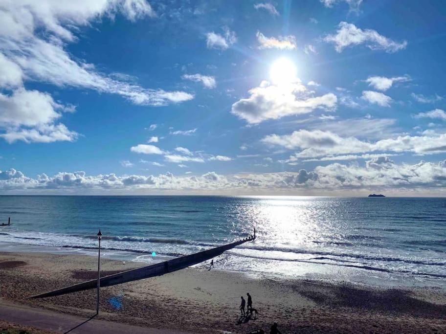 a beach with the sun shining on the water at Stunning Bright Two Bedroom Apartment In Southbourne in Southbourne