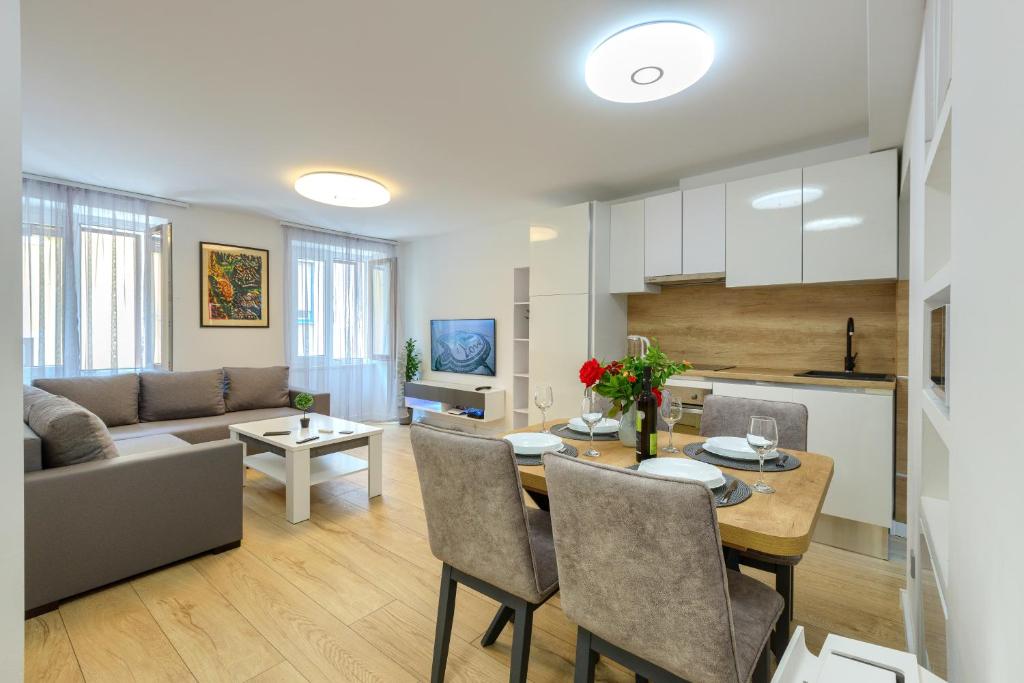 a kitchen and living room with a table and a couch at Apartment Tale - Brand new apartment in Pula's old town, with free Netflix and Wi-Fi in Pula