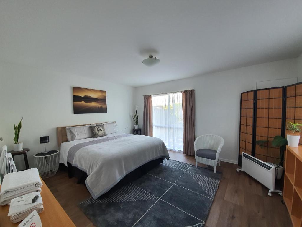 a bedroom with a large bed and a window at Alice House in Auckland