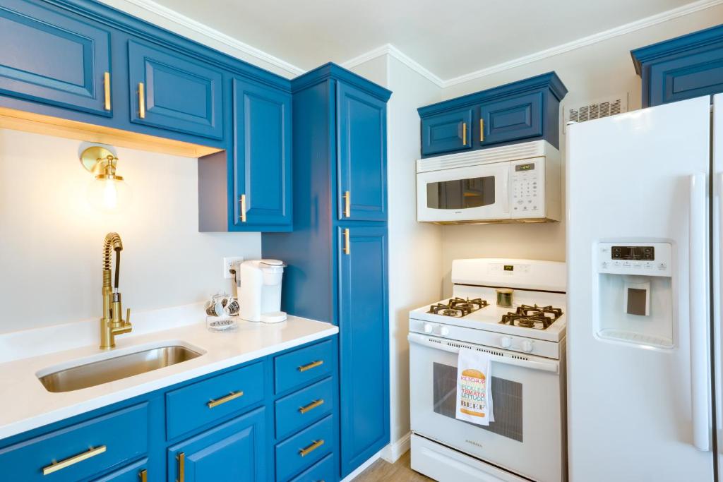 a kitchen with blue cabinets and a white refrigerator at Milwaukee Home with Serene Patio and Backyard Garden! in Milwaukee