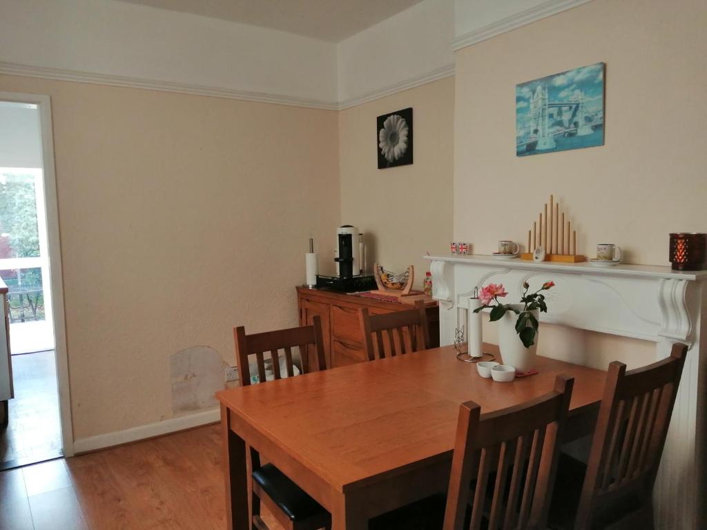 a dining room with a wooden table and a fireplace at Angelica place in Portsmouth