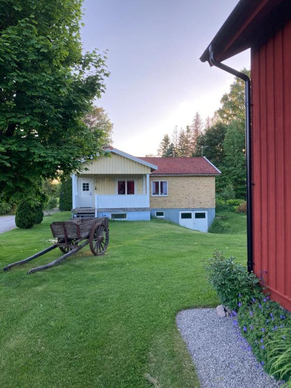 an old wagon in a yard next to a barn at Ta det lugnt in Råda