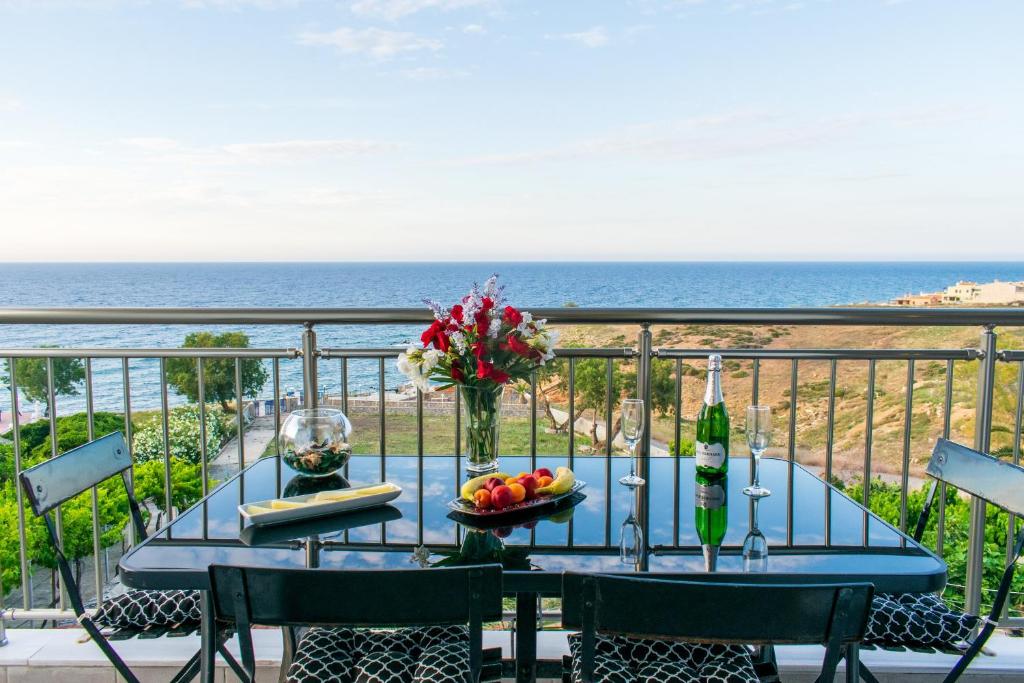 una mesa con un bol de fruta en el balcón con vistas al océano en Akontio Apartment with Sea View en Panormos Rethymno