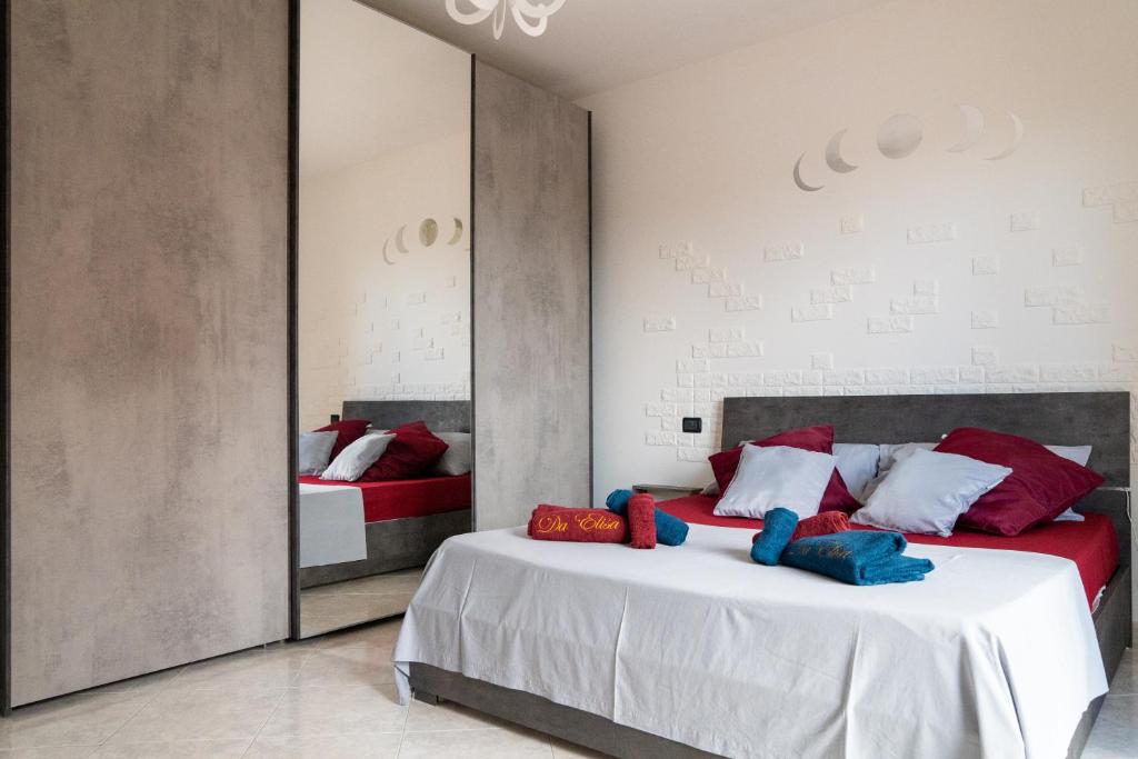 - une chambre avec 2 lits et un miroir dans l'établissement Da Elisa, à Quartu SantʼElena