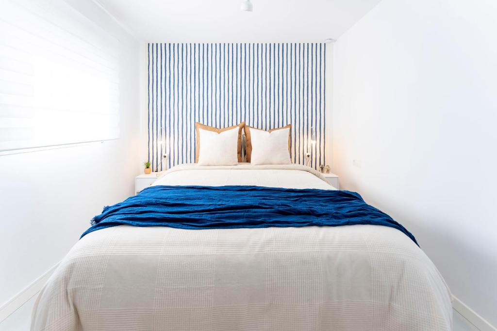 ein Schlafzimmer mit einem großen weißen Bett mit blauer Decke in der Unterkunft Apartamento de un dormitorio cerca de la playa in Estepona