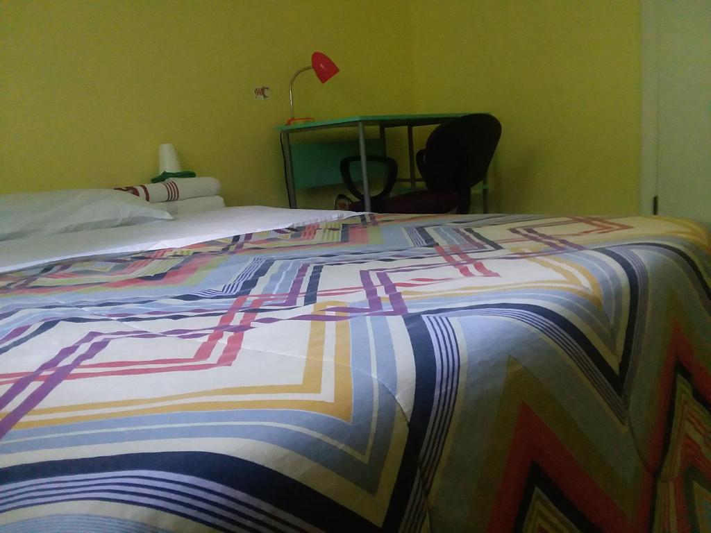 Una cama con una manta de colores encima. en Lovely Room, en Huntington