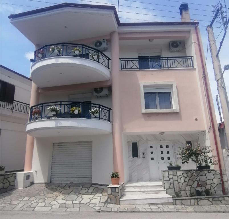 une grande maison blanche avec deux balcons. dans l'établissement Native Living, à Polychrono