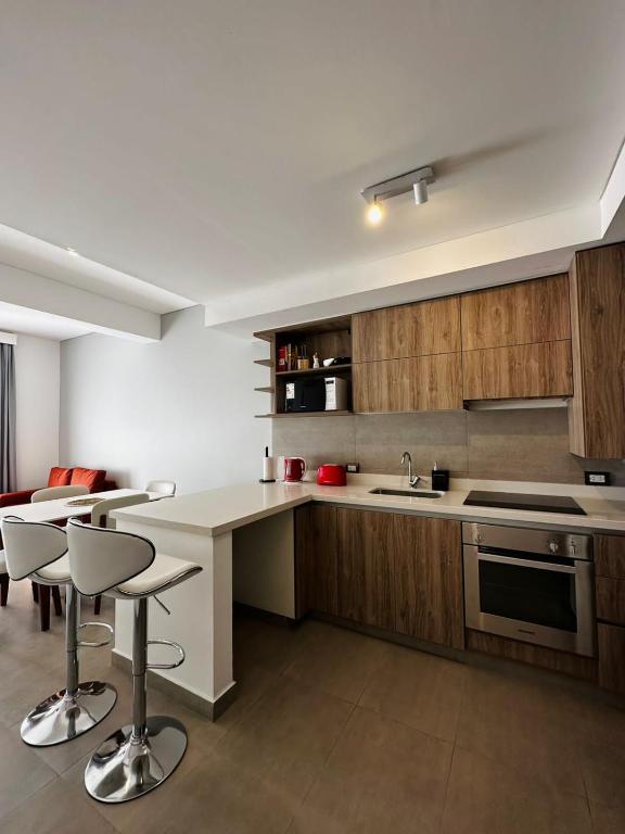 a kitchen with a counter and some chairs in it at DOMUM 144 in San Juan