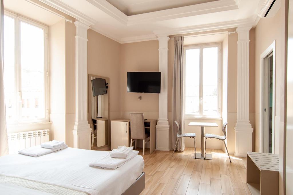 1 Schlafzimmer mit 2 Betten, einem Schreibtisch und einem TV in der Unterkunft Domus Porta Angelica in Rom