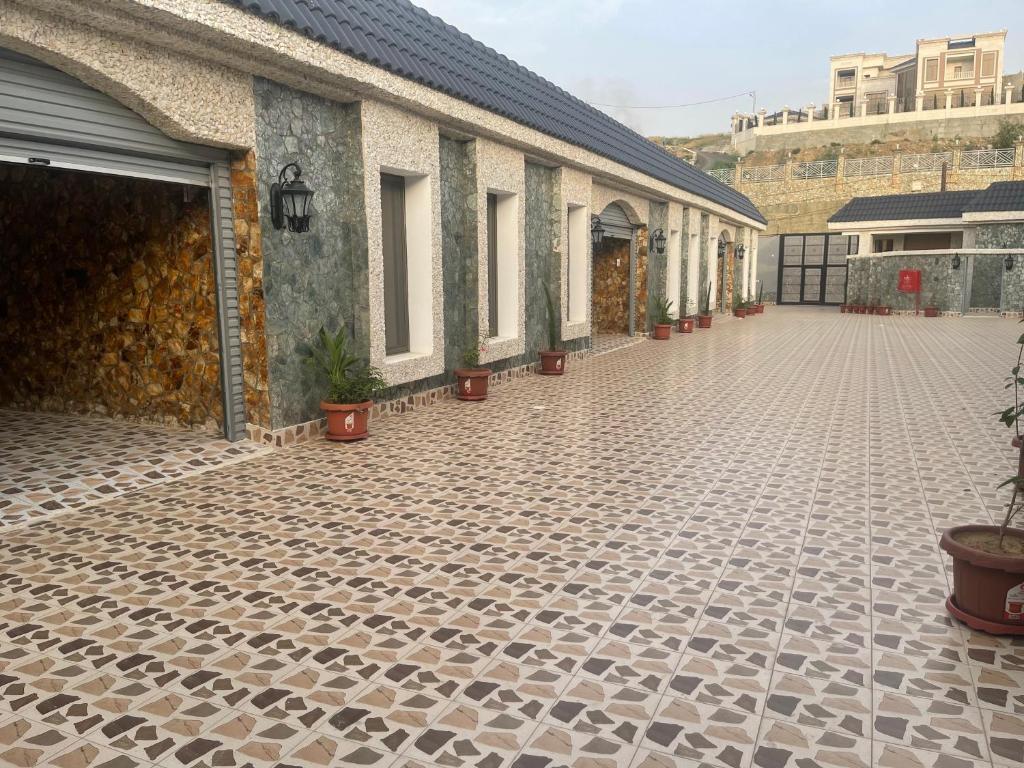 um pátio com vasos de plantas ao lado de um edifício em فلل بيات الفيصل Bayat Al Faisal Villas em Baljurashi