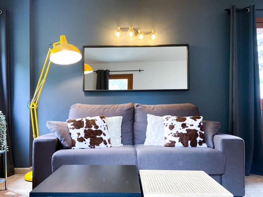 Moderno Y Rústico En Ransol 6pax في كانيلو: غرفة معيشة زرقاء مع أريكة ومرآة