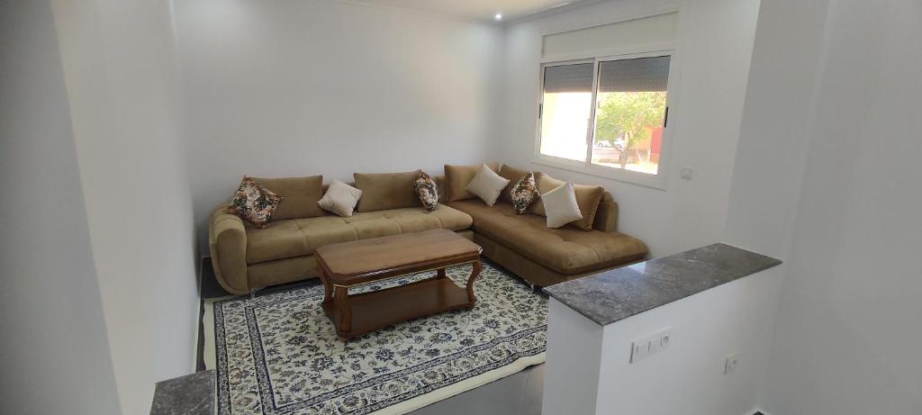 a living room with a couch and a table at Logement familial in Selouane