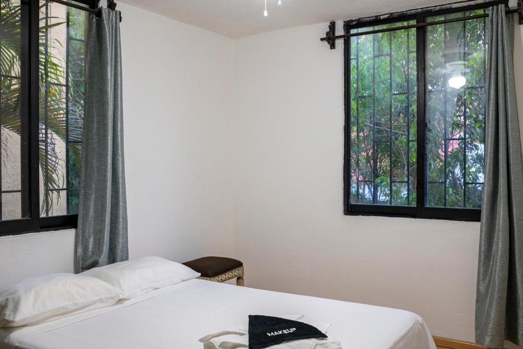 sypialnia z łóżkiem i 2 oknami w obiekcie Zely Home #2 w mieście Cancún