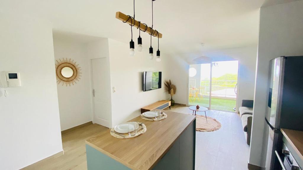 a kitchen with white walls and a table in a room at Appartement Océan View in Le Robert