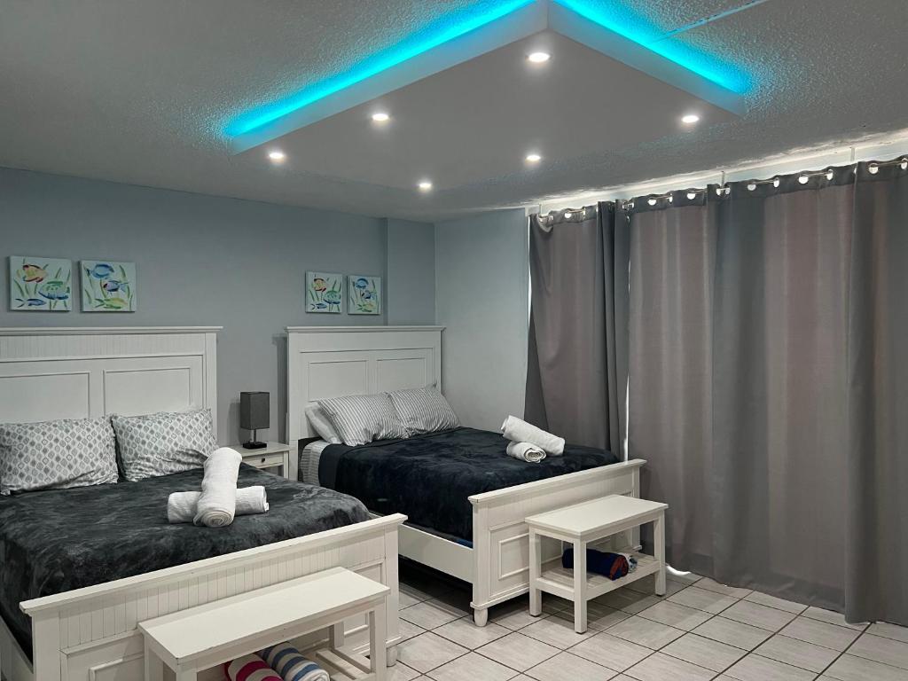 1 dormitorio con 2 camas y luz azul en Isla Verde Puerto Rico, Two Full Beds, en San Juan