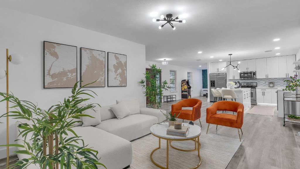 ein Wohnzimmer mit einem Sofa und Stühlen sowie eine Küche in der Unterkunft Sunny Escape: 5BD Home in Miami