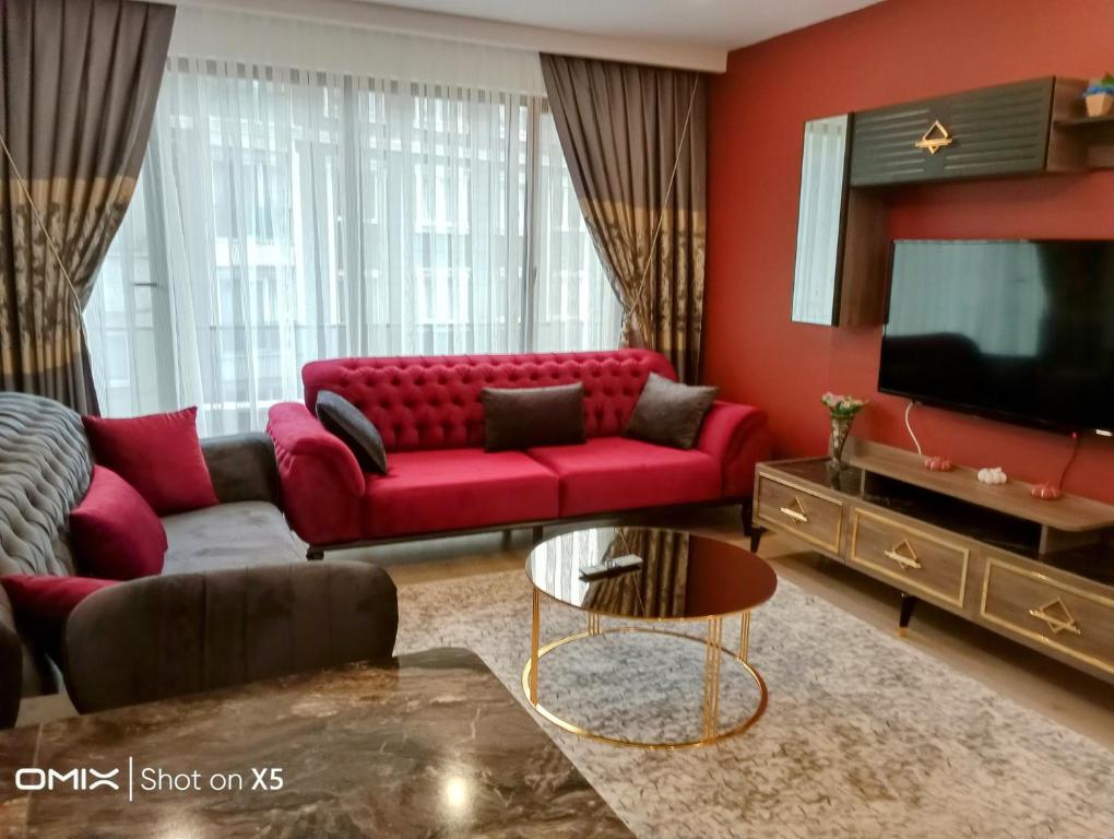 een woonkamer met een rode bank en een tv bij 2+1 lüks rezidans in Istanbul