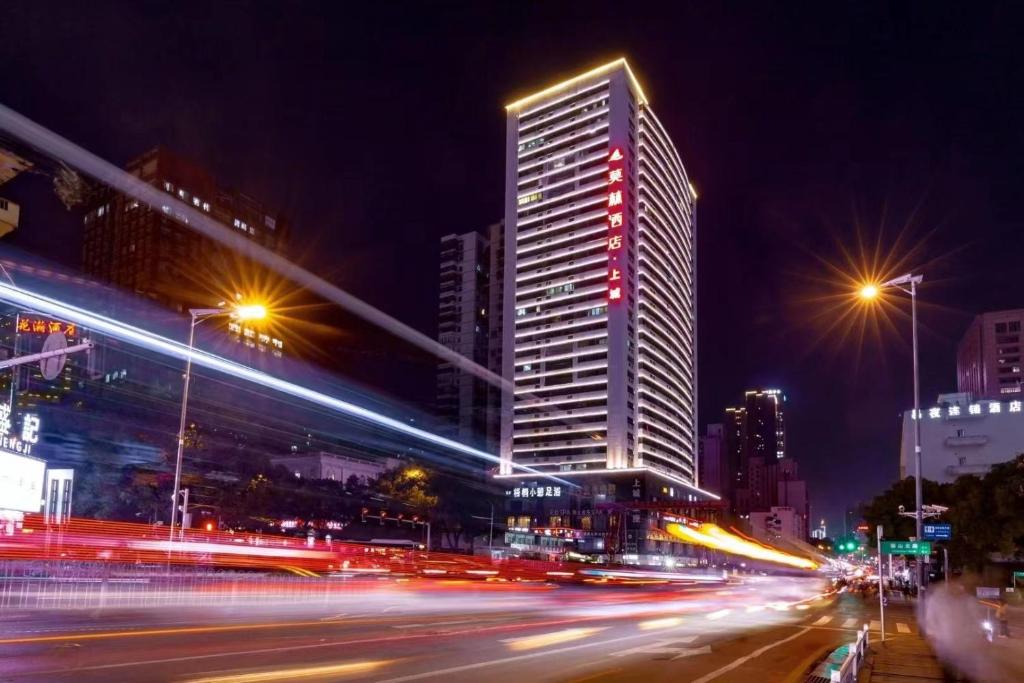 una calle de la ciudad por la noche con un edificio alto en Morning Hotel, Yaoling Xiangya Second Hospital Metro Station en Changsha