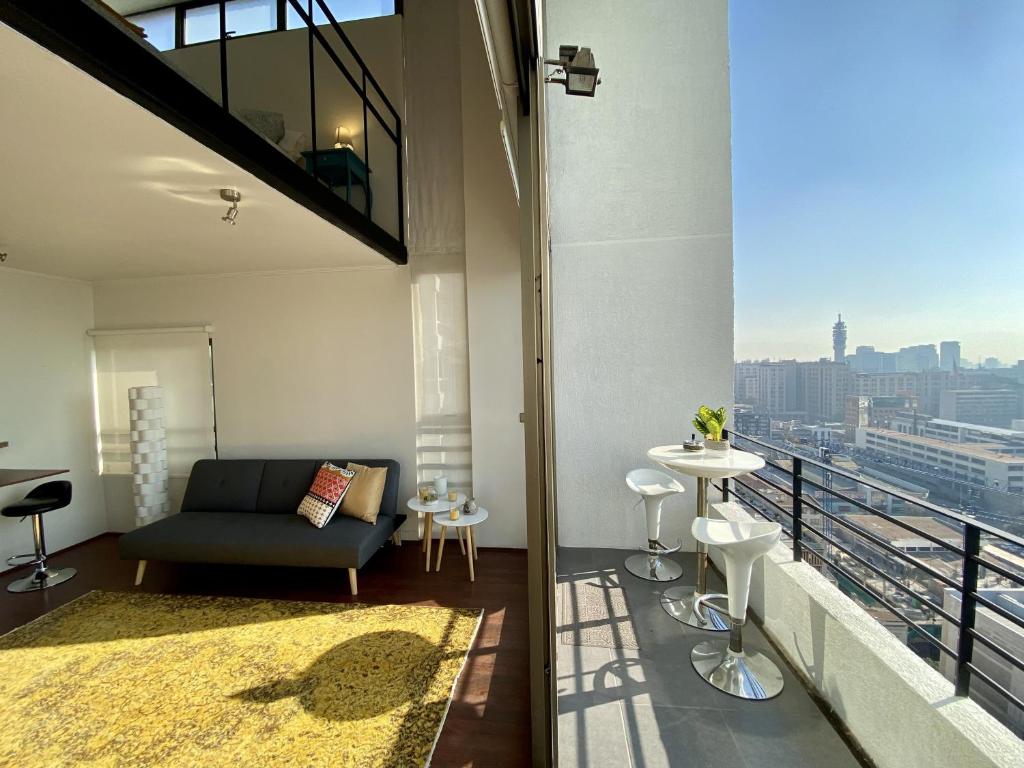 a living room with a couch and a balcony at Loft Panoramico - Santiago in Santiago