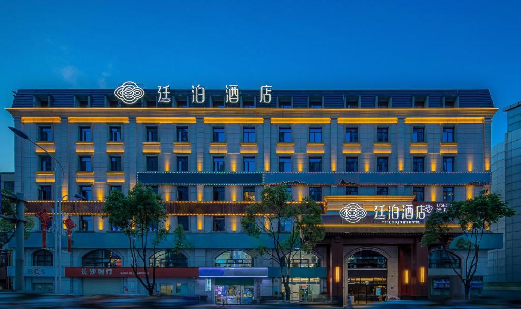 ein Gebäude mit einem Schild darüber in der Unterkunft Till Bright Hotel, Changsha Yanghu University of Traditional Chinese Medicine in Changsha