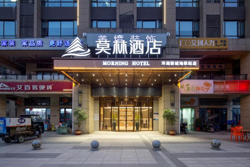 a building with a moving agent sign in front of it at Morning Hotel, Changsha Yanghu New City Metro Station in Changsha
