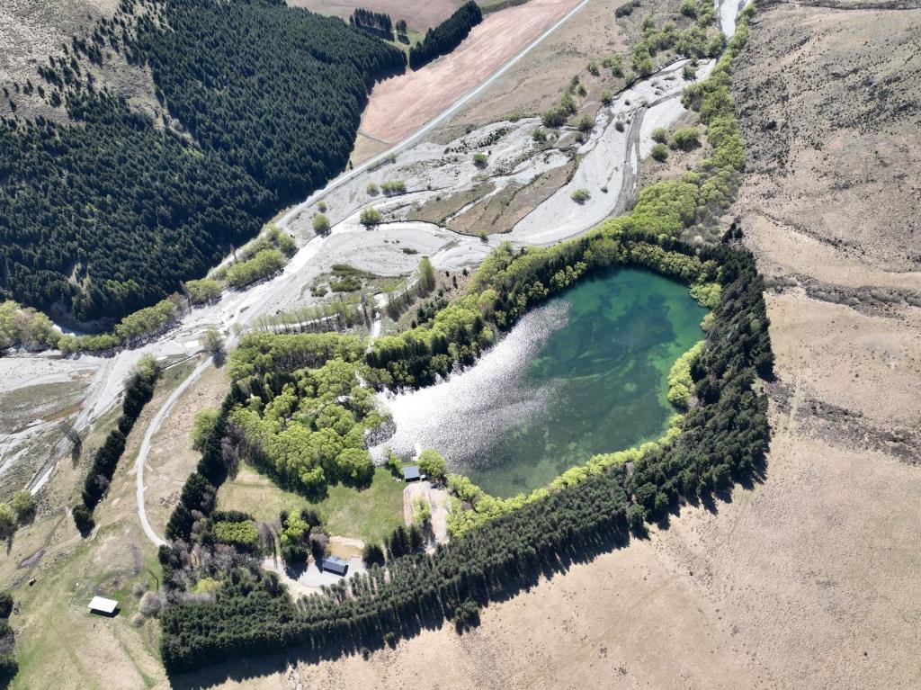 an aerial view of a lake on the side of a mountain at Blue Mountain Lake Lodge in Fairlie