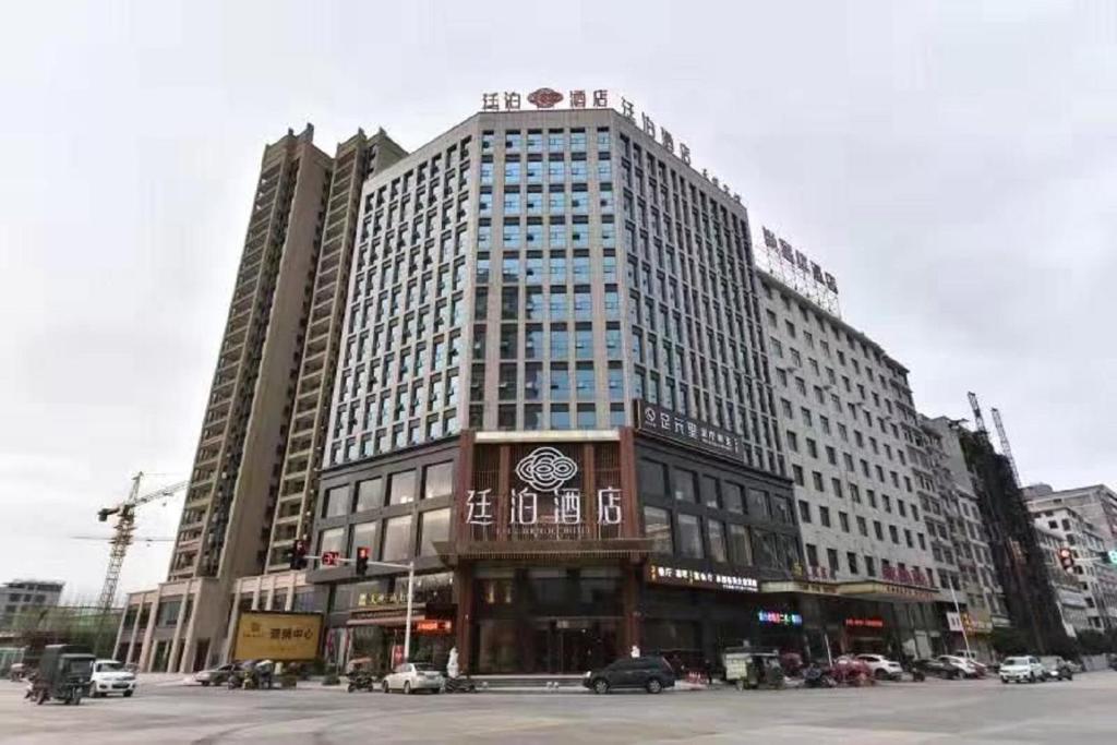 a large building with a clock on the front of it at Till Bright Hotel, Dongkou in Dongkou