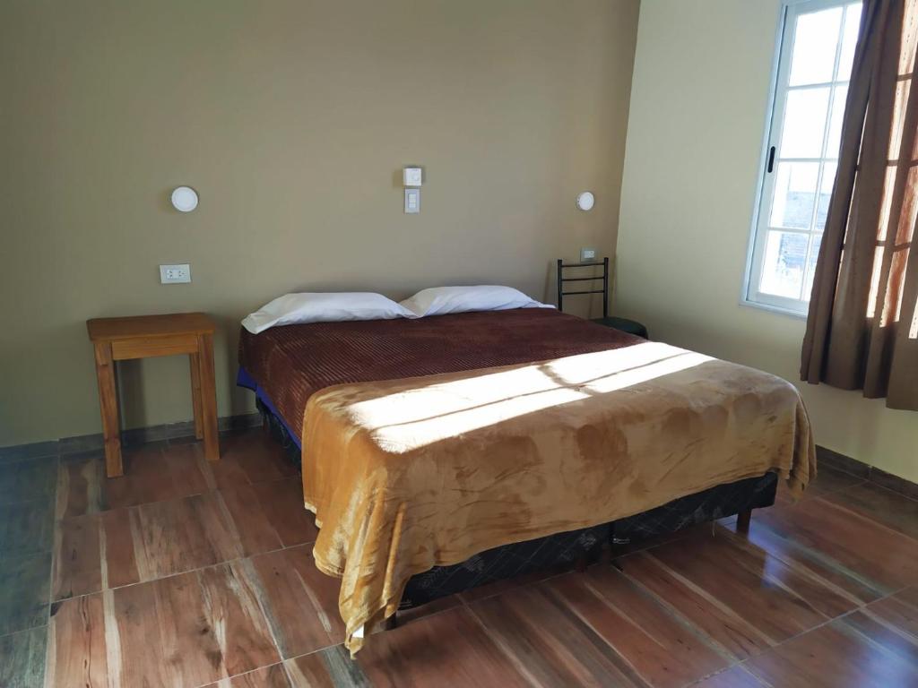 a bedroom with a large bed with a wooden floor at Departamento Aires del Golf in Termas de Río Hondo