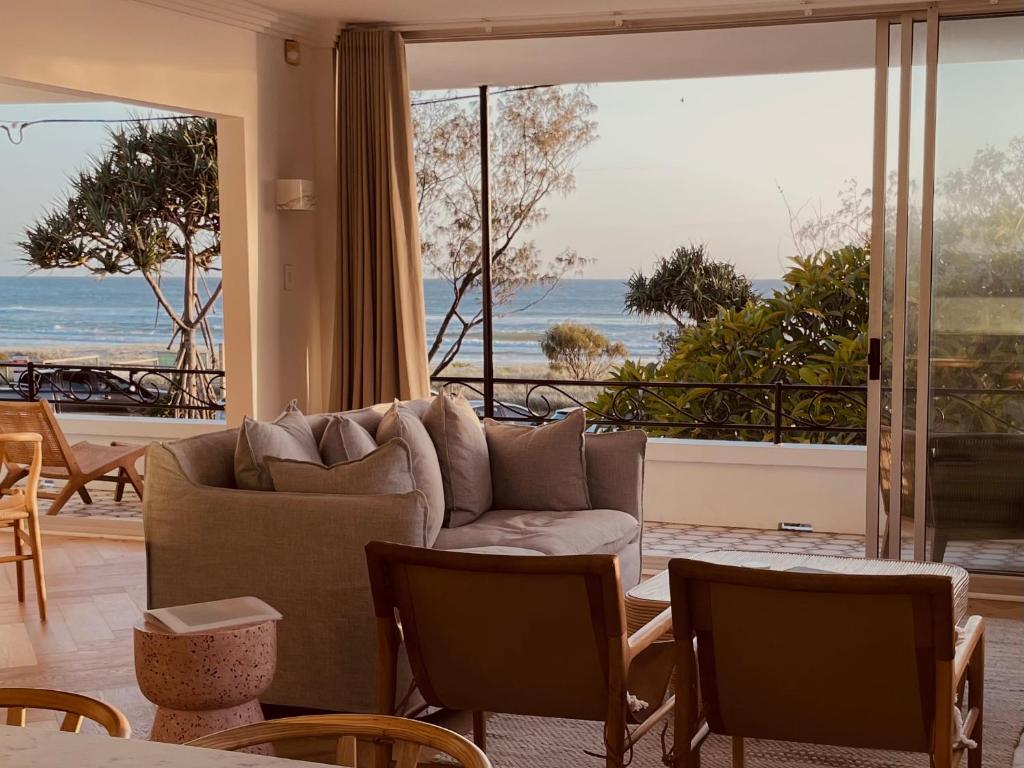 uma sala de estar com um sofá e vista para o oceano em Houston Beachfront Apartments em Gold Coast