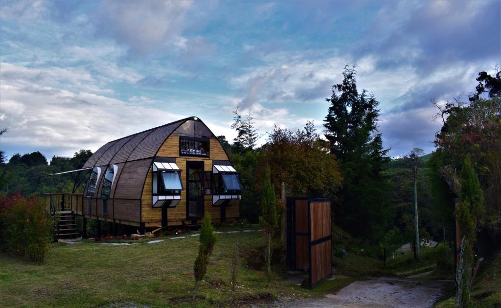 uma grande casa de madeira situada no topo de um campo em Chalet Petit Verdot em Medellín