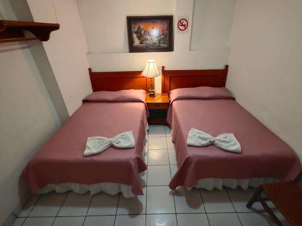 Dos camas en una habitación de hotel con arcos. en Hotel San Jose de la Montaña, en San Salvador