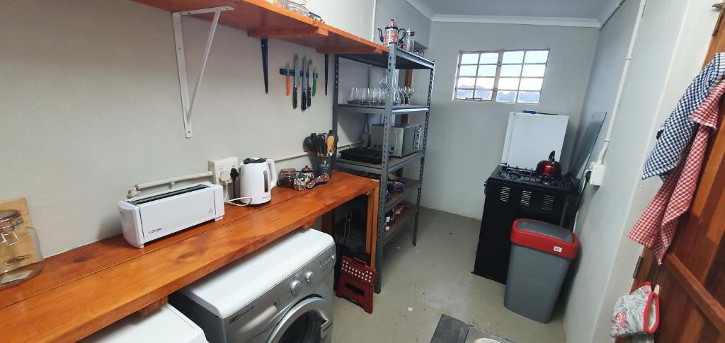 a kitchen with a counter and a washing machine at Karoo Leeu Cottage in Oudtshoorn
