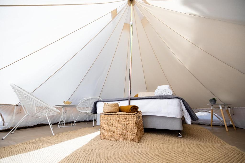 a bedroom with a tent with a bed and a table at Pure Glamping Guilderton in Guilderton