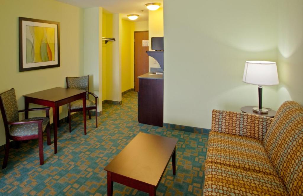a living room with a couch and a table and chairs at Holiday Inn Express Hotel & Suites Thornburg-S. Fredericksburg by IHG in Thornburg