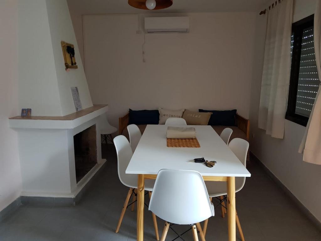 a dining room with a white table and white chairs at Residencial Las Lechuzas in Villa Anizacate