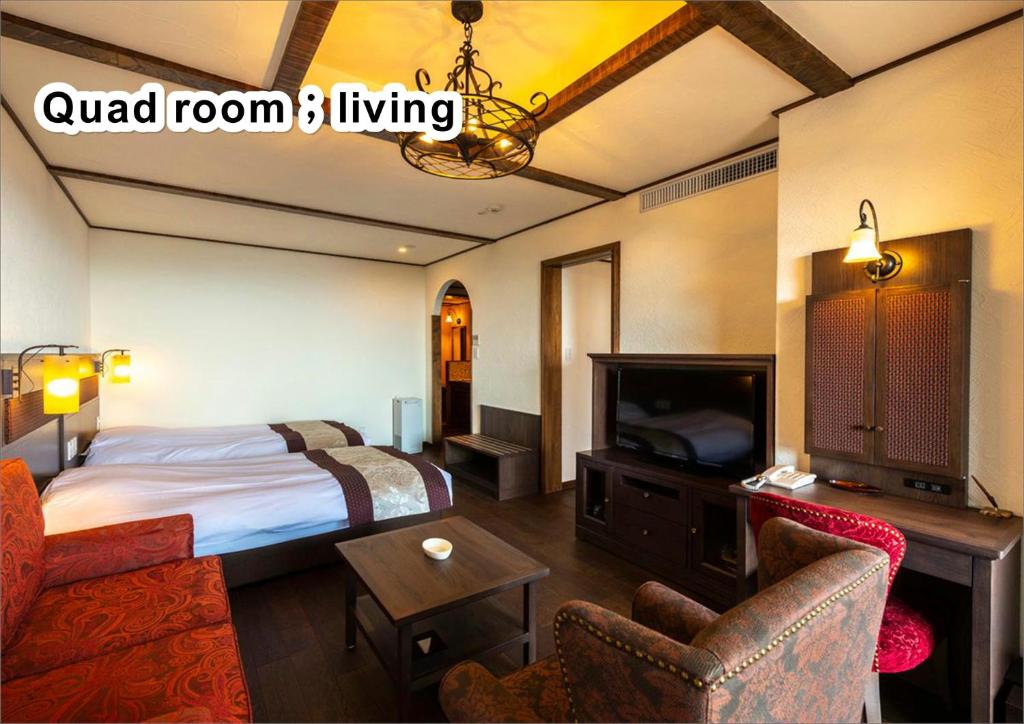 a hotel room with a bed and a tv at La Vista Kirishima Hills in Kirishima