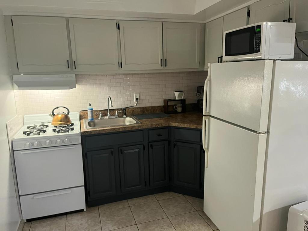 eine Küche mit weißen Geräten und einem weißen Kühlschrank in der Unterkunft Two Bedroom Private Apt near NYC in West New York