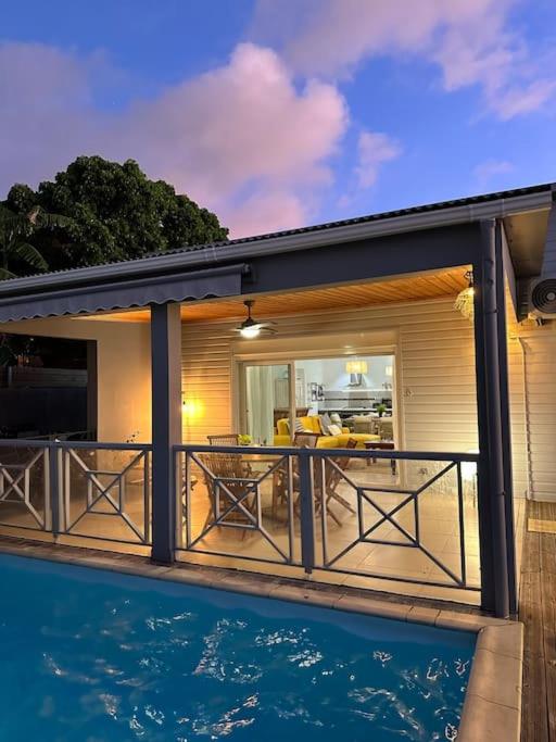 una casa con piscina frente a ella en Villa KasaLeu, en Saint-Leu