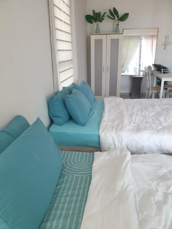 a living room with two beds and a couch at I-City Shah Alam Homestay, Studio, 2 Katil Queen, 1 Sofa, Balcony in Kampong Padang Jawa