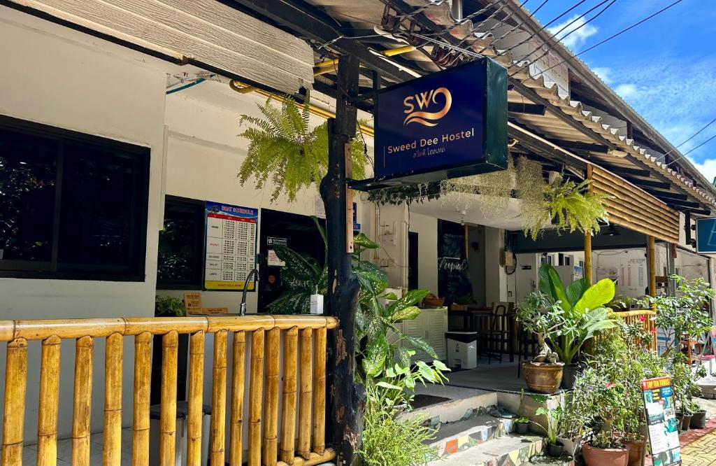 una señal en el lado de un edificio con plantas en Sweed Dee Hostel, en Islas Phi Phi