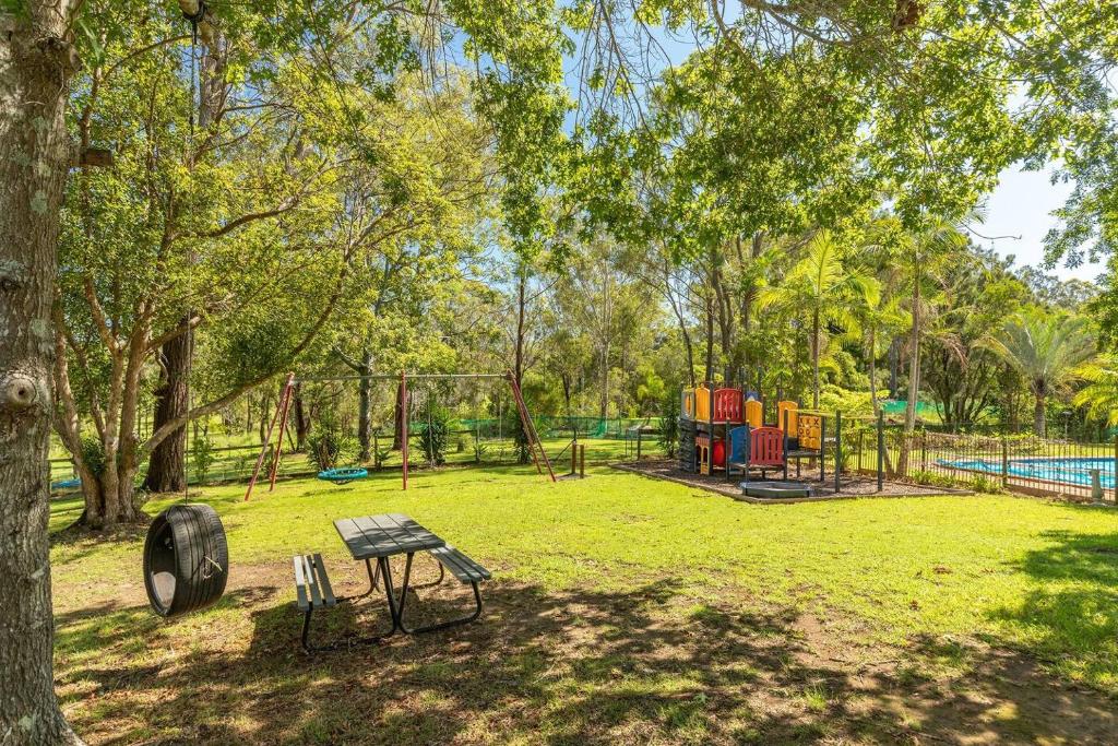 a park with a bench and a playground at Cundletown Cove in Cundletown