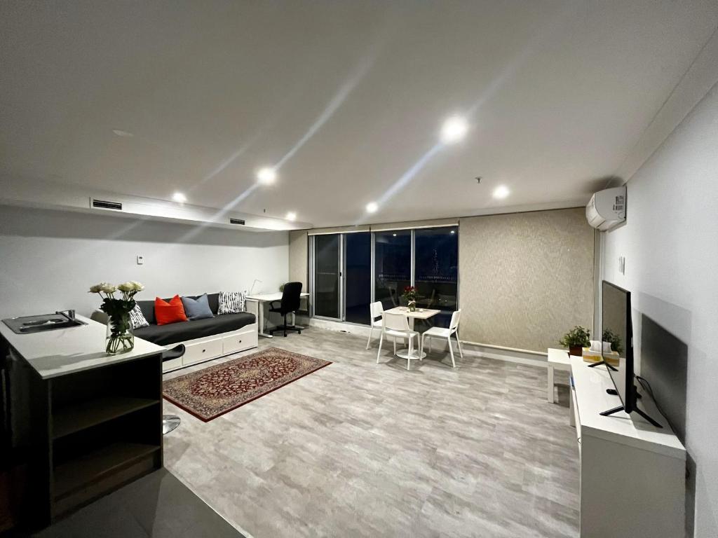 een woonkamer met een bank en een tafel bij One-bedroom Apartment in heart of the City in Canberra