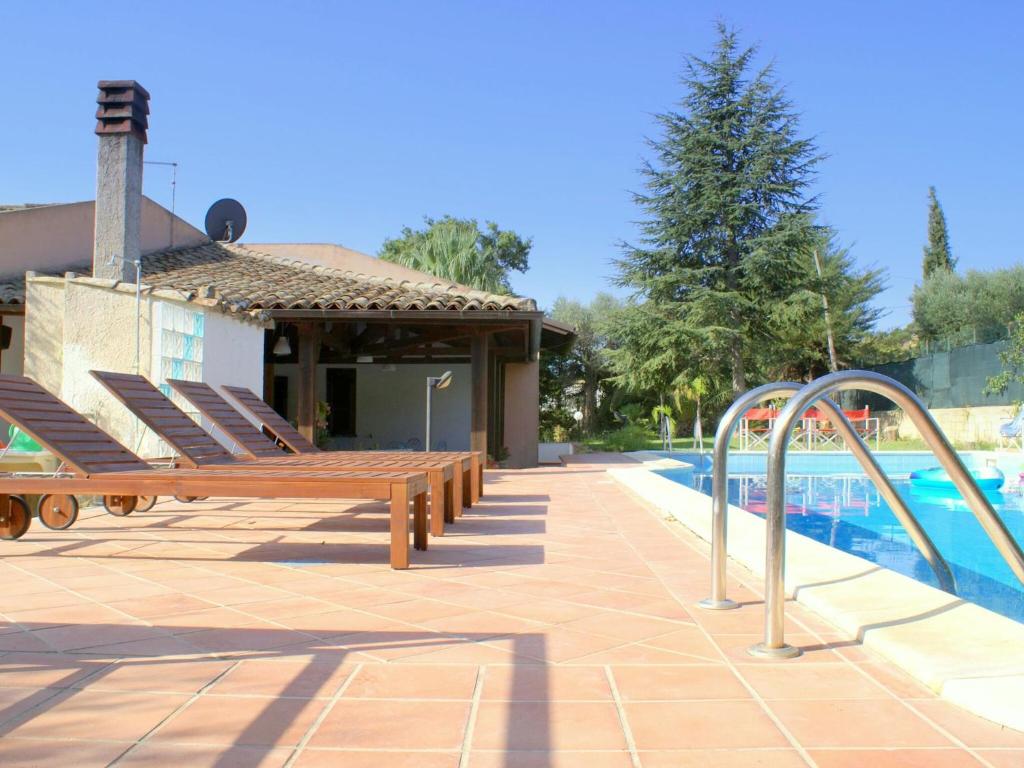 basen z ławkami obok budynku w obiekcie Modern Villa in Caltagirone Italy with Pool w mieście Caltagirone
