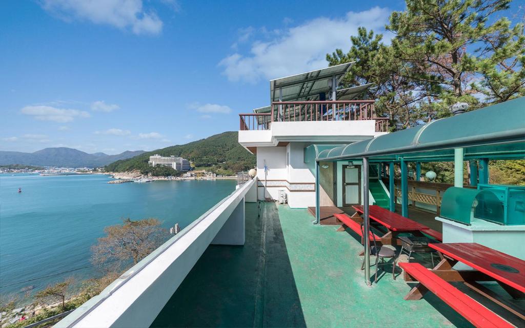 a building with benches on the edge of the water at Sunbeach Pension in Geoje 