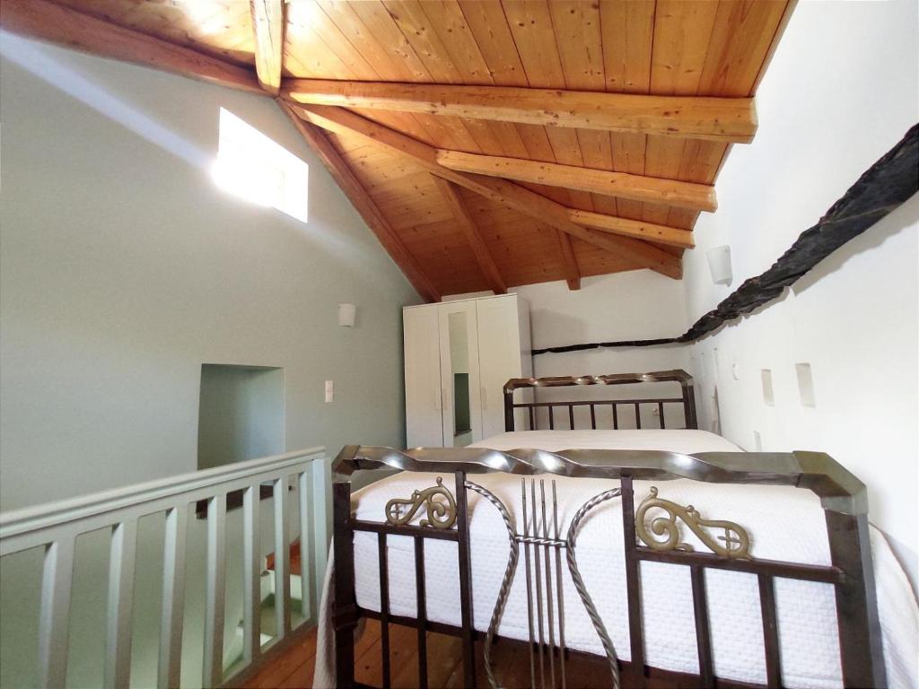 1 dormitorio con 2 camas y techo de madera en Stellinas Pretty House, en Ándros