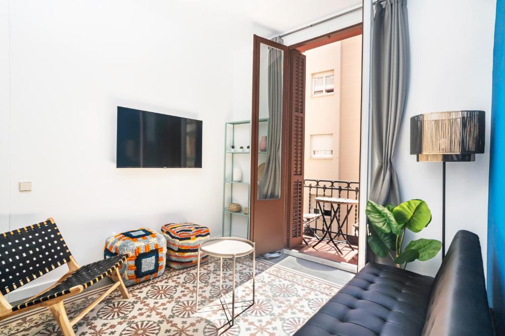 een woonkamer met een bank en een tv bij Caliu Apartments Barcelona in Hospitalet de Llobregat