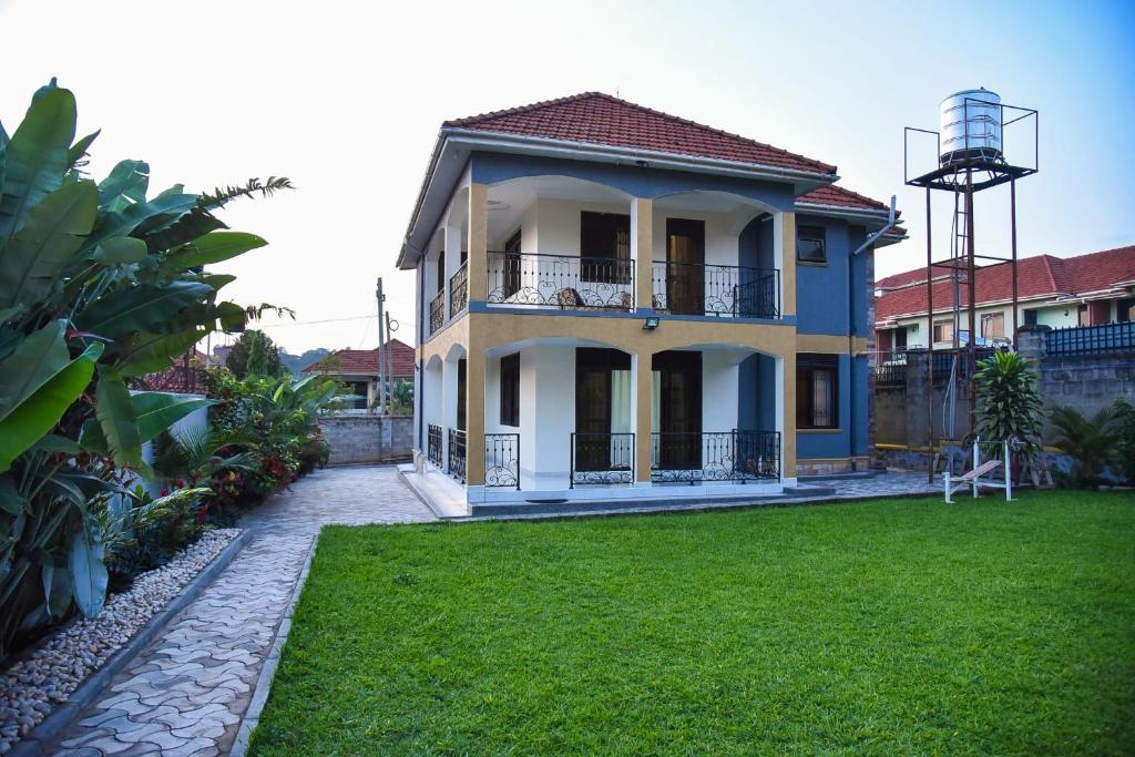 a large house with a green lawn in front of it at K-Cube Villas in Kampala