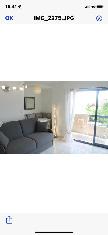 un salon avec un canapé et une grande fenêtre dans l'établissement Perla Di Mar, à Cavalaire-sur-Mer