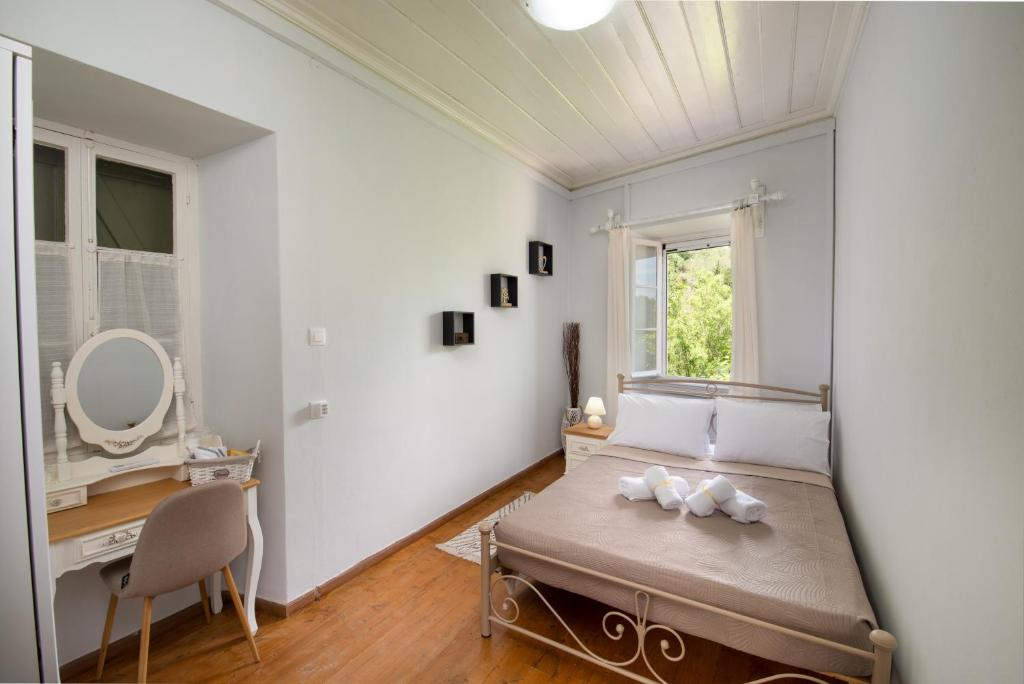 um quarto com uma cama, uma secretária e uma janela em Chrysa's Hideaway em Rantátika