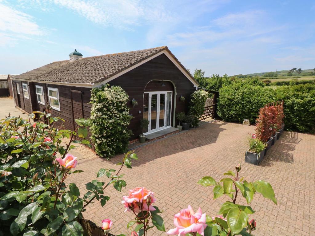 a small house with a brick patio and roses at The Coach House in Newport